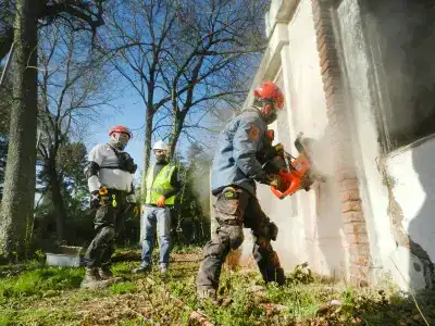 Un homme découpe un mur avec une grosse meuleuse d'angle béton